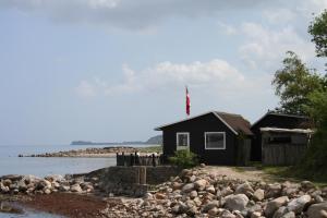 una casa nera sulla riva di un corpo d'acqua di Loff Holiday Houses a Aabenraa