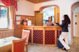 Una donna in piedi in un bar in un ristorante di Hotel Gran Fanes a Corvara in Badia