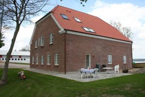 un grande edificio in mattoni con un tavolo di fronte di Loff Holiday Houses a Aabenraa