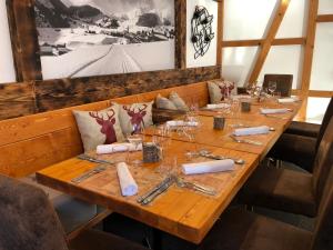 een lange houten tafel met glazen en servetten erop bij Mountain Lodge Sedrun in Sedrun