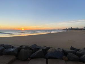 a sunset on a beach with rocks in the sand at Albur Village B - Gerbera in Alvor