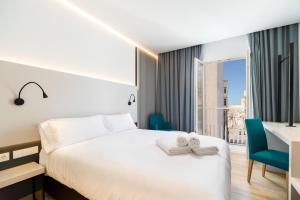 een hotelkamer met een bed, een bureau en een raam bij Dormos Hotel in Cádiz