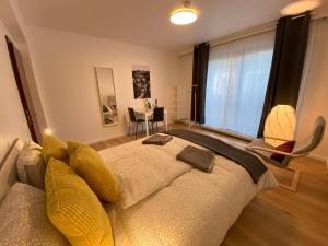 1 dormitorio con 1 cama grande con almohadas amarillas en Park City Center, en Luxemburgo