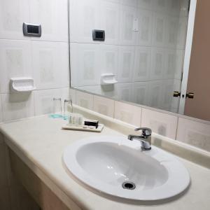 bagno con lavandino bianco e specchio di Hotel Gavina Express ad Arica