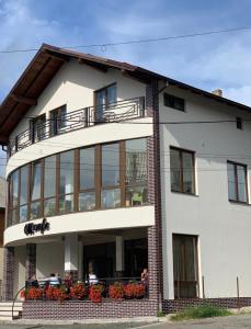 un grande edificio bianco con persone sedute sul balcone di Pensiunea OK a Vişeu de Sus