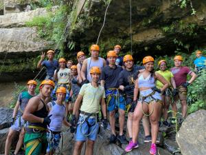 Un groupe de personnes portant des chapeaux durs orange posant pour une photo dans l'établissement Prana, à San Gil