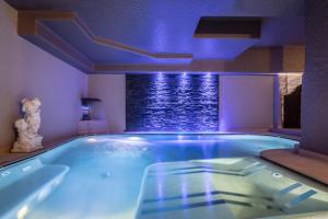 uma grande piscina com luzes azuis num quarto em Sporthotel Romantic Plaza em Madonna di Campiglio