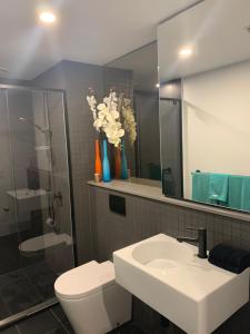 bagno con lavandino, servizi igienici e specchio di Midnight Luxe 1BR 1Bath Apartment 104 in the heart of Braddon Pool Sauna Secure Parking Wine WiFi a Canberra