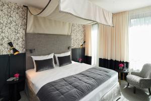 a bedroom with a large bed and a chair at Hotel am Ochsentor in Andernach