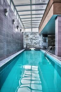 una piscina con acqua blu in un edificio di Casa Inn Galerias Celaya a Celaya