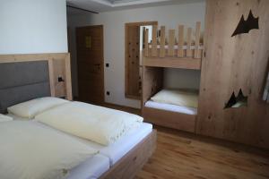 2 Betten in einem Zimmer mit 2 Etagenbetten in der Unterkunft Alpenhof Annaberg in Annaberg im Lammertal