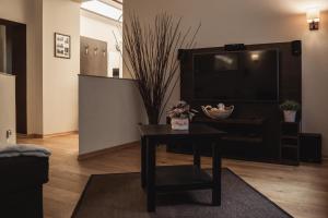 a living room with a table and a flat screen tv at athome IHR Apartment in Chemnitz