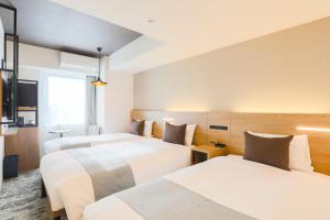 A bed or beds in a room at Hotel Wing International Sapporo Susukino