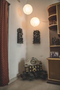 een kamer met twee lichten en een klok aan de muur bij Homestay for Women in Coimbatore