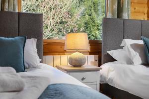 a bedroom with two beds and a lamp on a night stand at South Winchester Lodges in Winchester