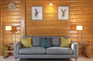 a living room with a gray couch with yellow pillows at South Winchester Lodges in Winchester