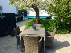 un tavolo con sedie e un albero nel patio di Kathrines Bed & Breakfast a Svendborg