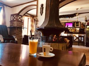 una mesa de madera con un vaso de zumo de naranja y una chimenea en Apartment 507 The Castle 1, en Pamporovo