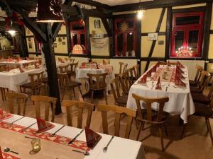 ein Esszimmer mit weißen Tischen und Stühlen in der Unterkunft Gasthaus Zur Weintraube in Bad Langensalza