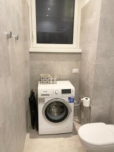 een wasmachine in een badkamer met een toilet bij Repubblica One Room Apartment in Milaan