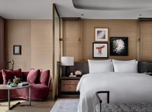 une chambre d'hôtel avec un lit et un canapé dans l'établissement Rosewood Guangzhou, à Canton