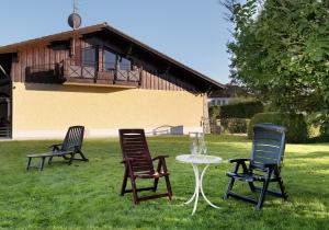 tre sedie e un tavolo nell'erba di Haus Josef Hager a Bad Füssing