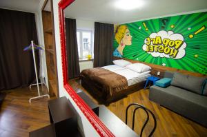 um quarto com uma cama e uma sala de estar com um sofá em Pop Art Hostel Rynok Sq em Lviv