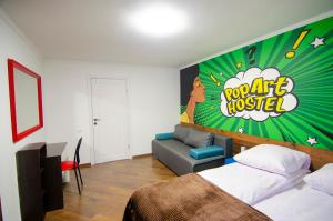 um quarto com uma cama, um sofá e uma placa em Pop Art Hostel Rynok Sq em Lviv