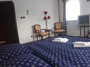 een slaapkamer met een bed met handdoeken erop bij Vila Madudu in Vălenii de Munte