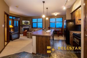 a kitchen and living room with a couch and a table at Glacier Mountaineer Lodge in Golden