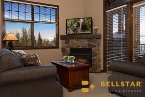 a living room with two couches and a fireplace at Glacier Mountaineer Lodge in Golden