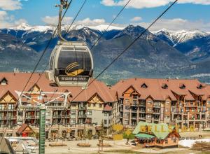 a gondola ride in front of a resort with mountains at Glacier Mountaineer Lodge in Golden