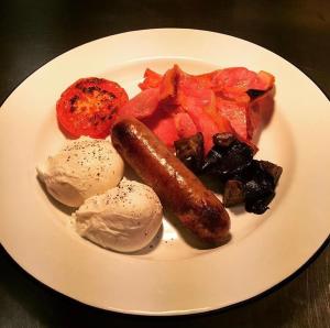 une assiette de nourriture avec saucisse et légumes sur une table dans l'établissement The Black Hole, à Winchester