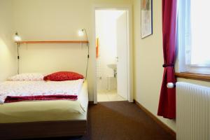 una piccola camera con letto e bagno di ARNOLDS Bed & Breakfast a Interlaken