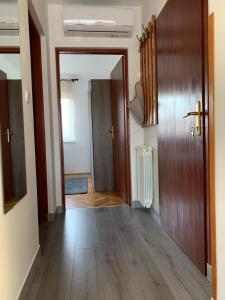 un corridoio vuoto con pavimento in legno e porta di Apartman MADAPE a Sesvete