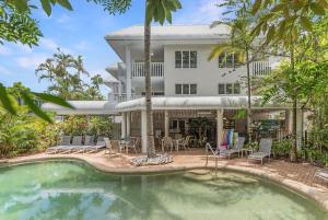 uma casa com piscina em frente a uma casa em Outrigger Apartments Port Douglas em Port Douglas