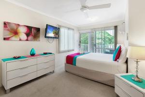 um quarto branco com uma cama e uma janela em Outrigger Apartments Port Douglas em Port Douglas