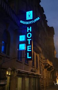 een neonbord aan de zijkant van een gebouw bij Wasserturm Hotel Mannheim in Mannheim