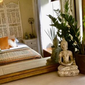 Cette chambre comprend un lit et une statue sur une table. dans l'établissement Bambu Cottage, à Newquay