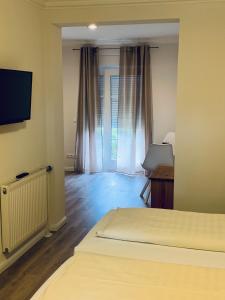 Zimmer mit 2 Betten und einem TV in einem Zimmer in der Unterkunft Landhotel Franck Garni in Brietlingen