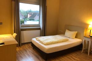 ein Schlafzimmer mit einem Bett und einem großen Fenster in der Unterkunft Landhotel Franck Garni in Brietlingen