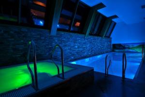 a swimming pool in a house with green lights at Hotel Bystra in Białka Tatrzanska