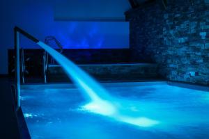 a swimming pool with blue lighting in a room at Hotel Bystra in Białka Tatrzanska