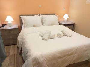 a bedroom with a white bed with towels on it at CityZen Rooms Chios in Chios