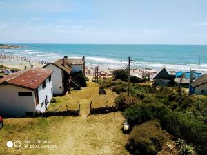 Blick auf einen Strand mit einem Gebäude und das Meer in der Unterkunft La Posada in Punta Del Diablo