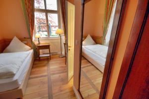 a small room with two beds and a window at Schloss Burgellern in Scheßlitz