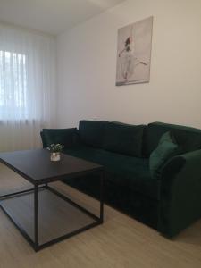 a living room with a green couch and a coffee table at Parko apartamentai in Panevėžys