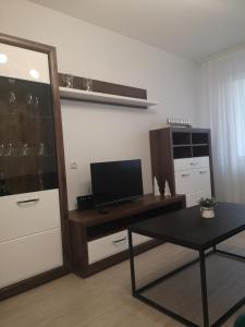 a living room with a desk with a television and a table at Parko apartamentai in Panevėžys