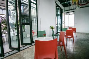 Cette chambre comprend une table, des chaises et des fenêtres. dans l'établissement Fine Bed Hotel, à Nonthaburi