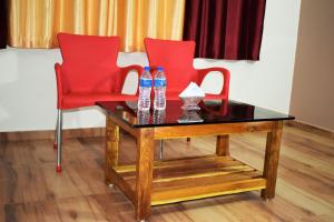 two red chairs and a table with water bottles on it at Viraz Valley in Gokarna